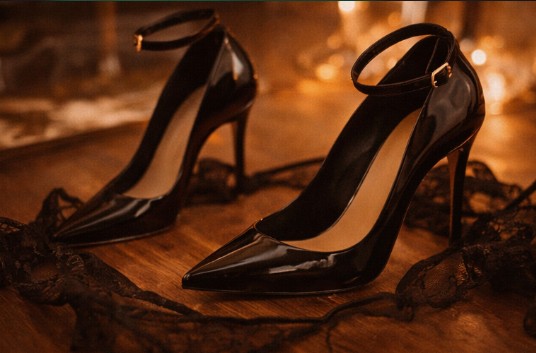 Черные лакированные туфли на каблуке на деревянной поверхности